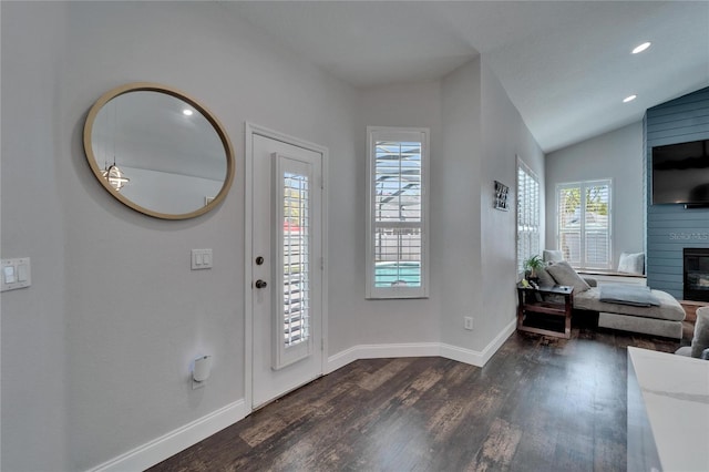 entryway featuring a large fireplace, baseboards, vaulted ceiling, recessed lighting, and dark wood-style flooring