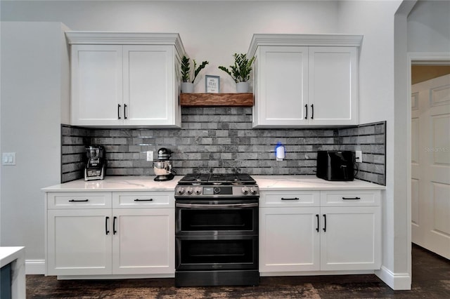 kitchen featuring range with two ovens, white cabinets, and backsplash