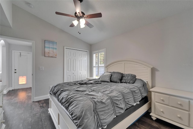 bedroom featuring vaulted ceiling, baseboards, dark wood-type flooring, and a closet