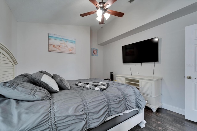 bedroom featuring baseboards, dark wood-style floors, a ceiling fan, and vaulted ceiling