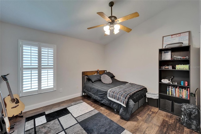 bedroom featuring baseboards, a ceiling fan, lofted ceiling, and wood finished floors