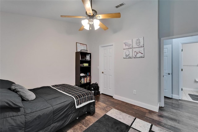 bedroom with ceiling fan, visible vents, baseboards, and wood finished floors