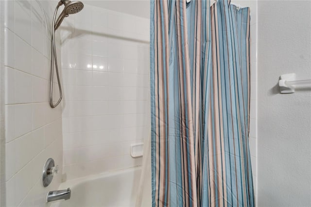 bathroom featuring shower / tub combo and a textured wall