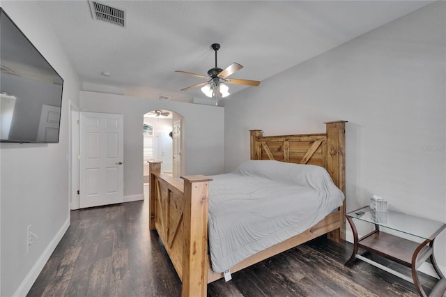 bedroom featuring visible vents, ceiling fan, baseboards, wood finished floors, and arched walkways