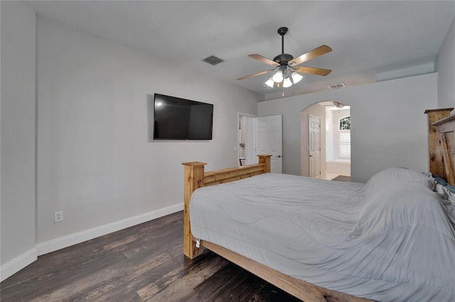 bedroom with arched walkways, visible vents, baseboards, and wood finished floors