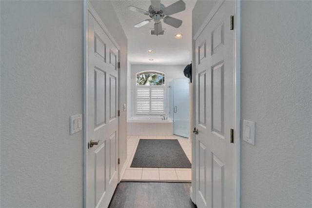 hall featuring recessed lighting, wood finished floors, and a textured wall