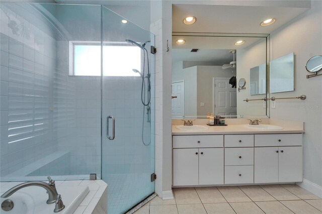 full bath featuring tile patterned flooring, a shower stall, double vanity, a bath, and a sink