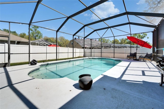 view of pool with glass enclosure, a patio, a fenced in pool, and fence