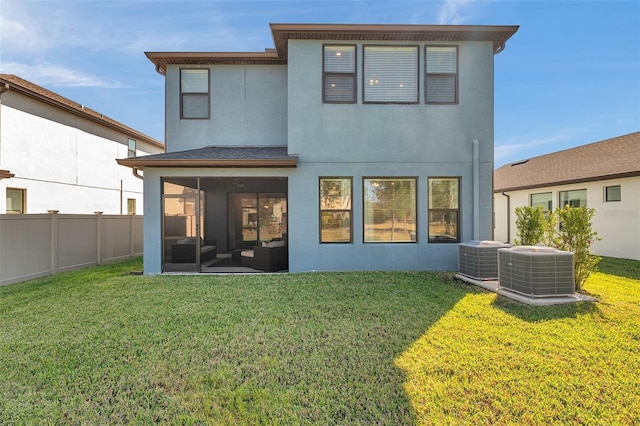 rear view of property featuring stucco siding, a lawn, cooling unit, and fence