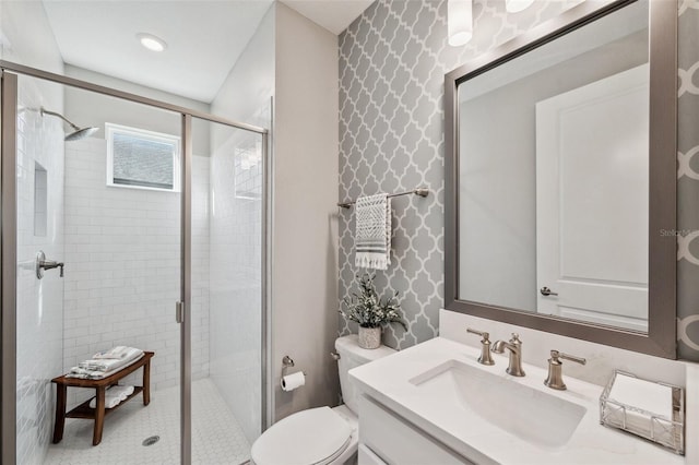 full bathroom featuring toilet, a stall shower, wallpapered walls, and vanity