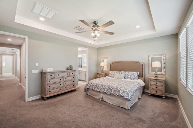 carpeted bedroom with a tray ceiling and visible vents