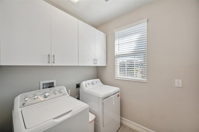 laundry room featuring baseboards, cabinet space, and washer and clothes dryer