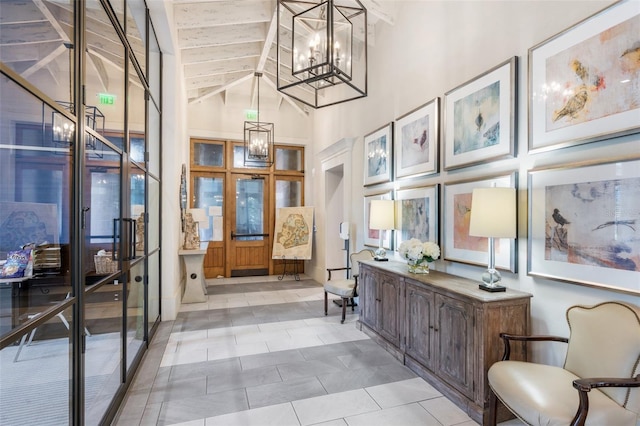 interior space featuring beam ceiling, a notable chandelier, high vaulted ceiling, french doors, and light tile patterned flooring