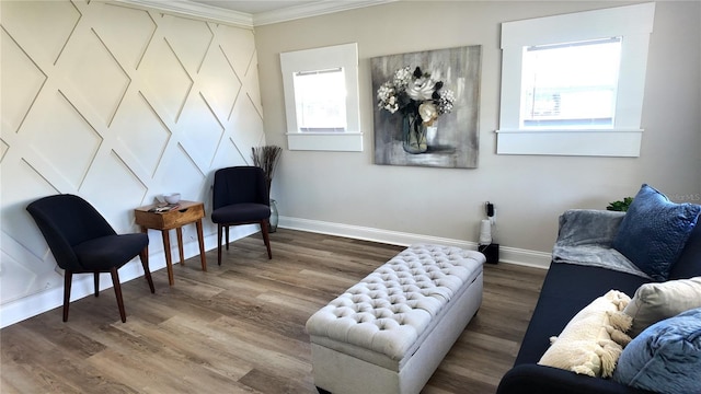 sitting room with crown molding, wood finished floors, and baseboards