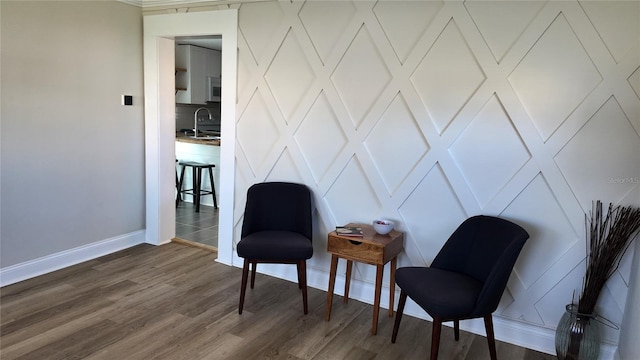 sitting room with baseboards and dark wood-style flooring