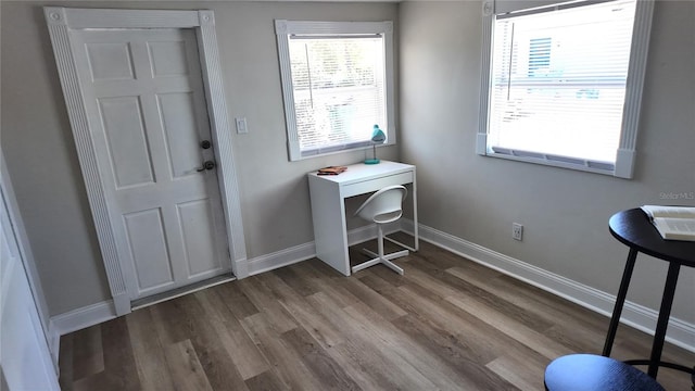 doorway featuring baseboards and dark wood-style floors