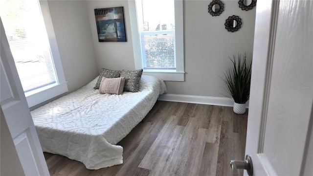 bedroom with baseboards and wood finished floors