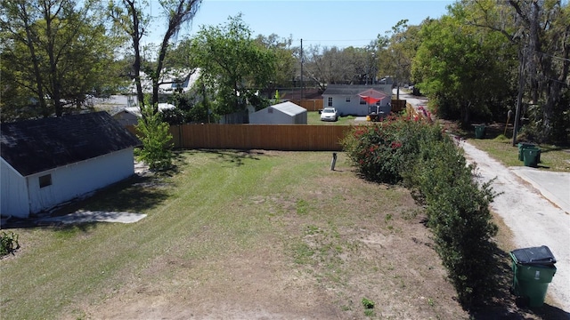 view of yard featuring dirt driveway and fence