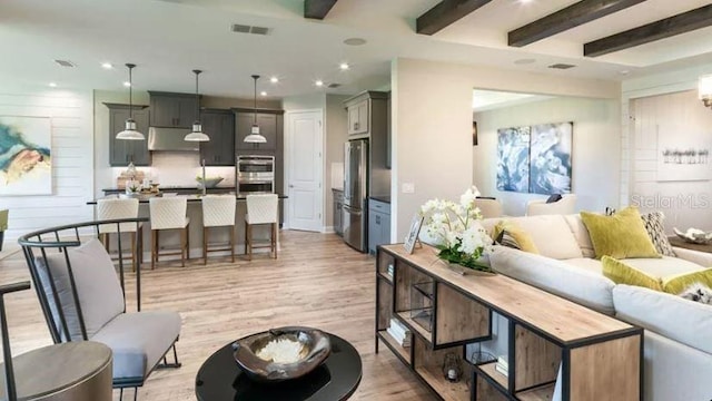 living room featuring recessed lighting, visible vents, beamed ceiling, and light wood-style flooring