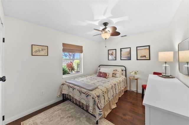 bedroom with visible vents, a ceiling fan, baseboards, and wood finished floors