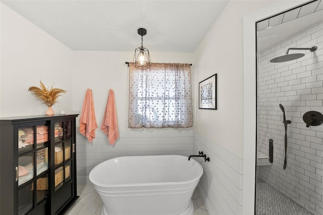 full bathroom with a freestanding tub, tile walls, a shower stall, and tile patterned flooring