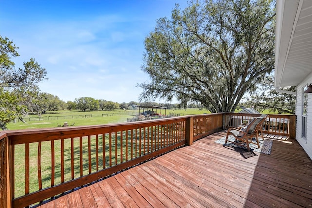 wooden deck with a yard, a trampoline, and a rural view