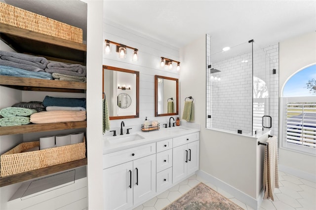 full bathroom featuring double vanity, a shower stall, tile patterned floors, and a sink