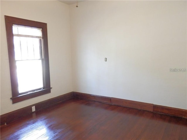 unfurnished room featuring baseboards and wood finished floors