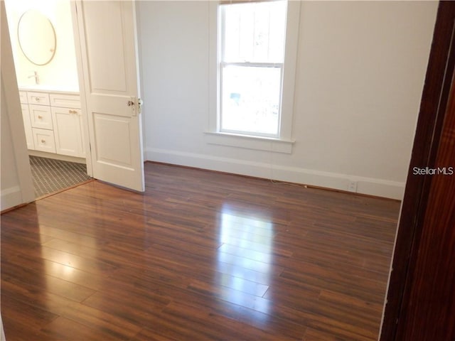 unfurnished bedroom with dark wood-style floors and baseboards