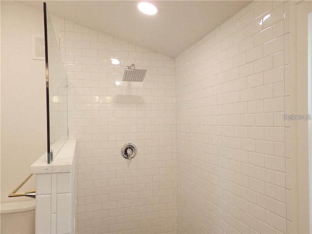 room details featuring recessed lighting, toilet, and a tile shower