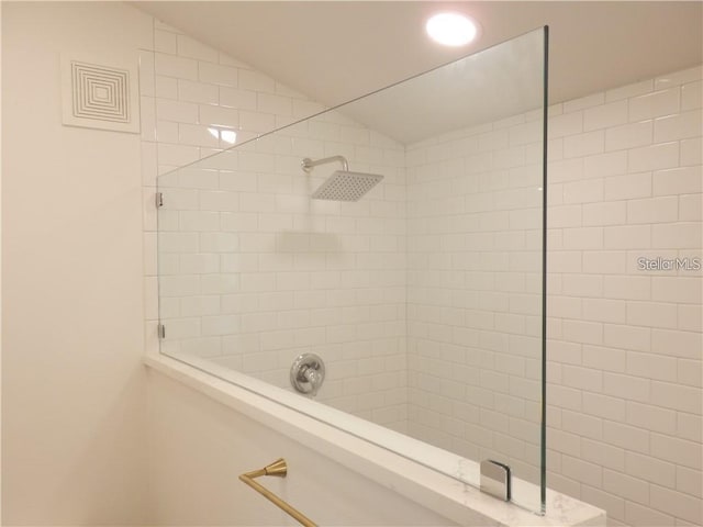 full bath featuring tiled shower and lofted ceiling