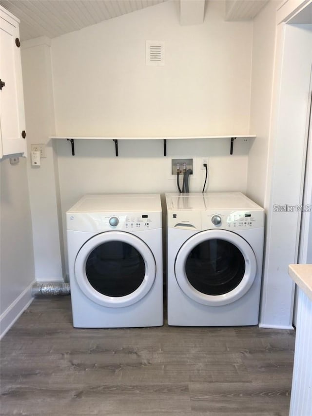 washroom featuring laundry area, separate washer and dryer, dark wood-type flooring, and visible vents