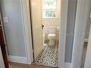 bathroom featuring tile walls, toilet, and tile patterned floors