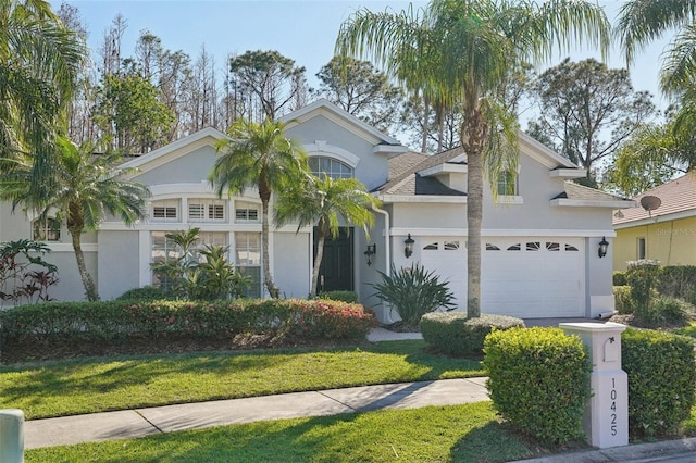 view of front facade featuring stucco siding, an attached garage, and a shingled roof