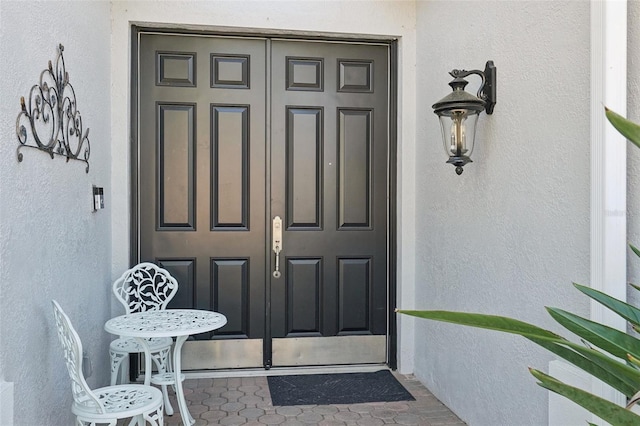 view of exterior entry with stucco siding