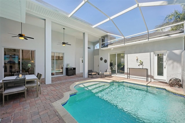 pool featuring glass enclosure, a ceiling fan, and a patio area