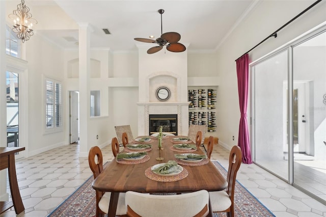 dining space featuring visible vents, a high ceiling, ornamental molding, and a fireplace