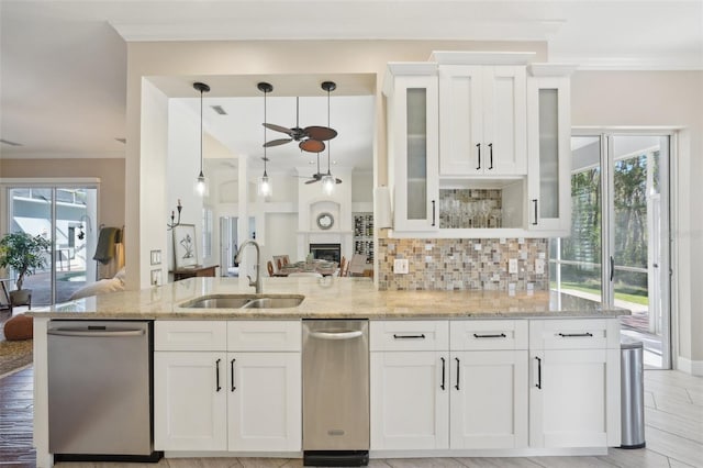 kitchen with a sink, decorative backsplash, light stone countertops, and dishwasher