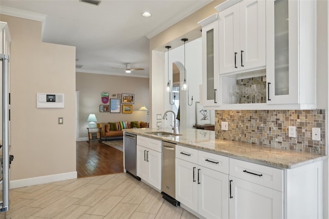 kitchen with decorative backsplash, crown molding, open floor plan, and a sink