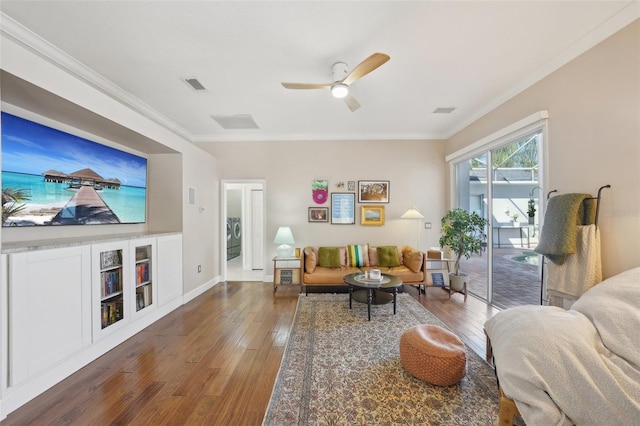 living room with crown molding, hardwood / wood-style flooring, and visible vents