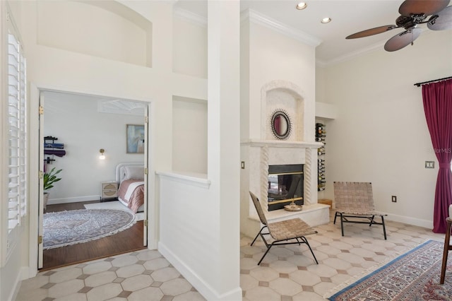 interior space with baseboards, a premium fireplace, a high ceiling, recessed lighting, and ornamental molding