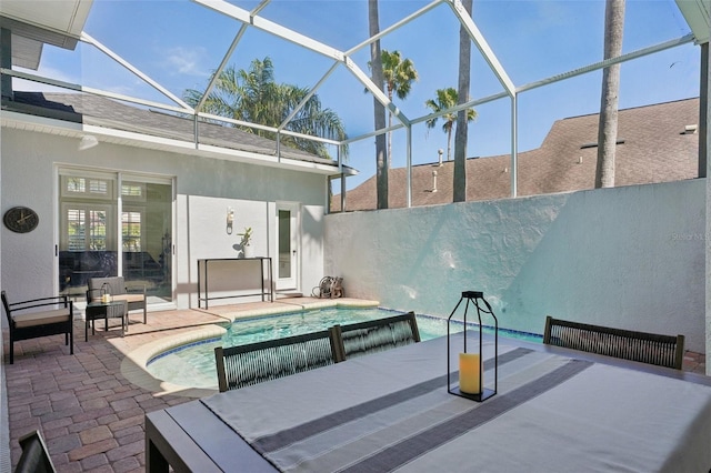 outdoor pool with a patio, an in ground hot tub, a lanai, and fence