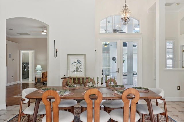 dining room featuring arched walkways, ceiling fan with notable chandelier, french doors, and ornamental molding