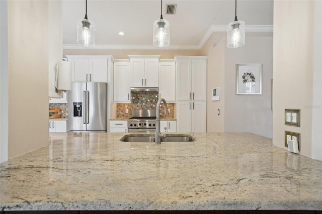 kitchen featuring tasteful backsplash, visible vents, ornamental molding, high end fridge, and a sink