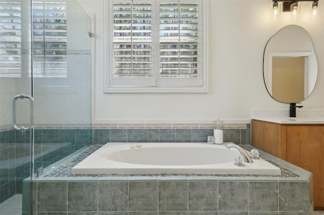 full bathroom with a bath, a shower stall, and vanity