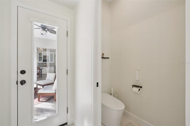 bathroom featuring toilet, a ceiling fan, and baseboards