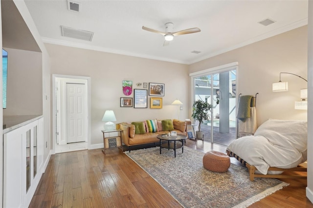 living room featuring hardwood / wood-style floors, crown molding, and visible vents