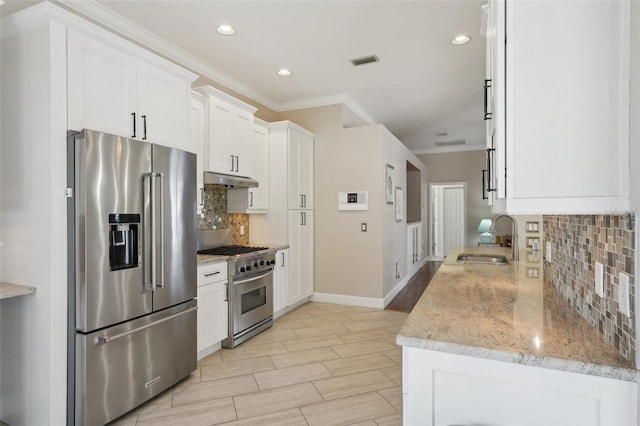 kitchen featuring visible vents, crown molding, high quality appliances, white cabinetry, and a sink