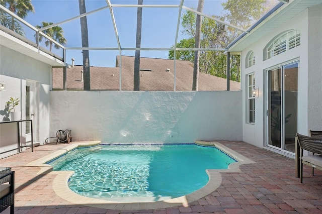 pool with glass enclosure, a patio, and fence