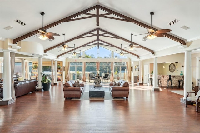 living room with visible vents, high vaulted ceiling, wood finished floors, and ornate columns